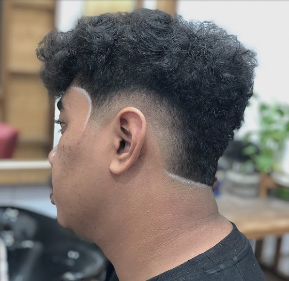 Curly top haircut with a crisp, clean-lined low fade