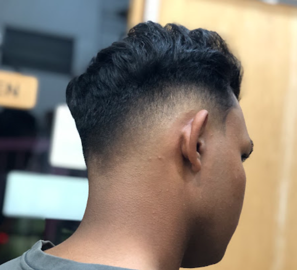 Textured brushed-back haircut with a low skin fade