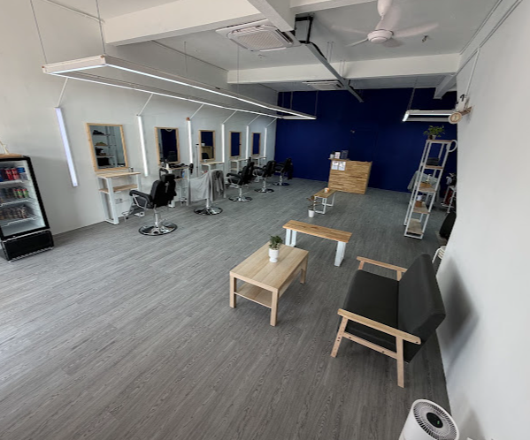 Full view of Sizzer Barbershop Kajang showing styling stations, seating area and navy accent wall